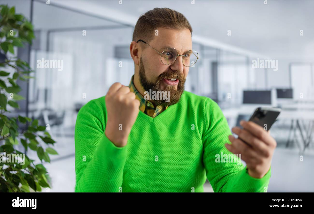 Mann im Büro mit guten Nachrichten Stockfoto