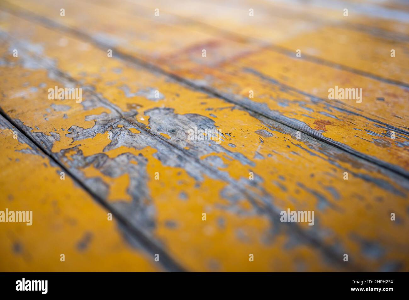 Alte Bretter mit rissiger gelber Farbe. Klassischer rustikaler Hintergrund. Stockfoto