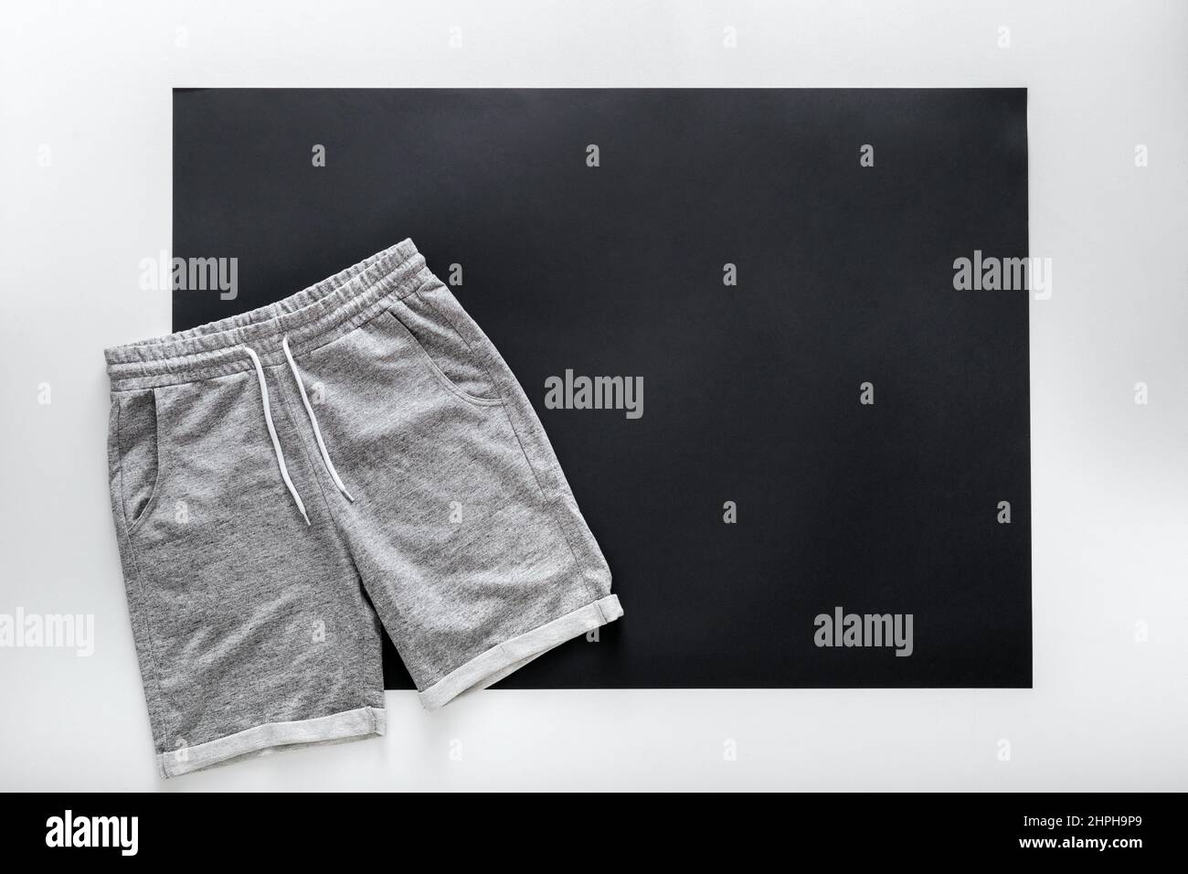 Graue Shorts Hose für den Männersport. Basic Freizeitkleidung Sport grauen männlichen Shorts auf weißem schwarzen Rahmen Hintergrund mit Kopie Platz. Minimalistisches Basic Stockfoto