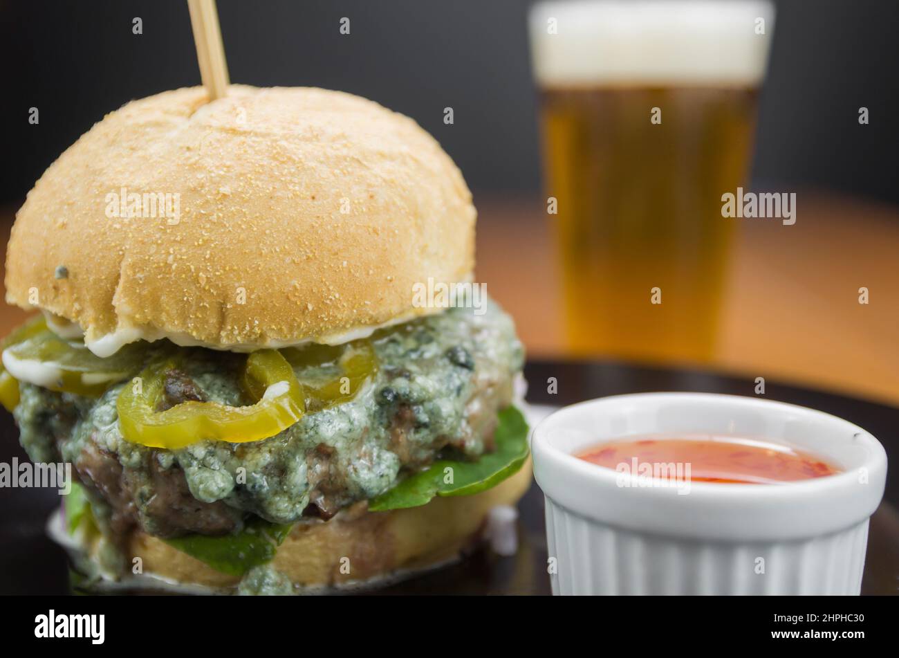 Nahaufnahme von leckeren hausgemachten Hamburgern auf Holztisch und schwarzem Hintergrund Stockfoto