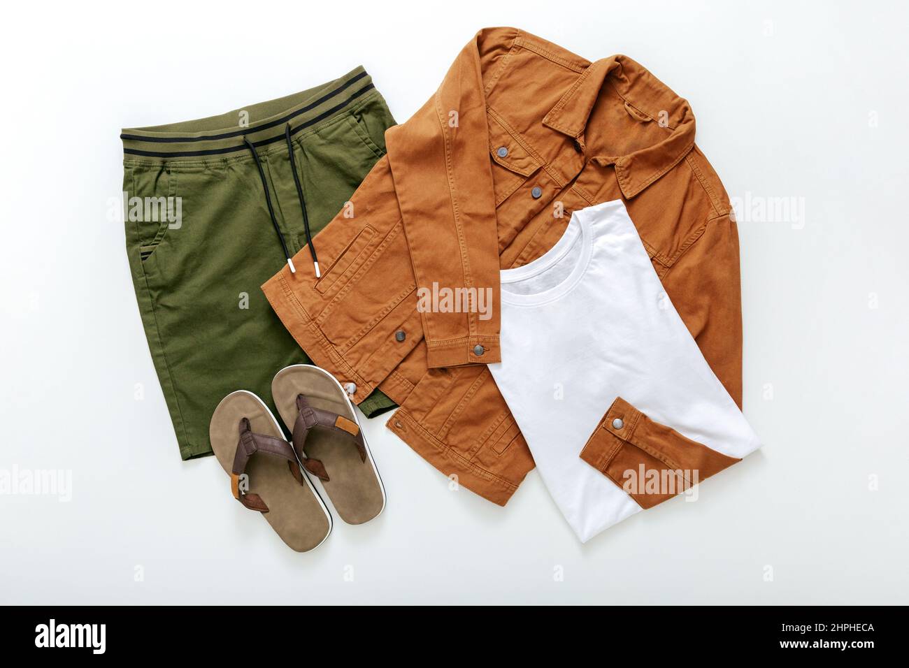 Set von stilvollen Kleidung Flip Flop Schiefer T-Shirt Shorts Denim Jacke auf weißem Hintergrund Draufsicht. Sommerkleidung für Herren legere Outfits. Modisch Stockfoto