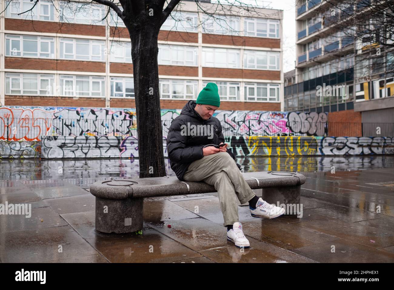 Etwas Ruhe und Frieden auf einer nassen Bank in der Old Street, London, Großbritannien. Stockfoto