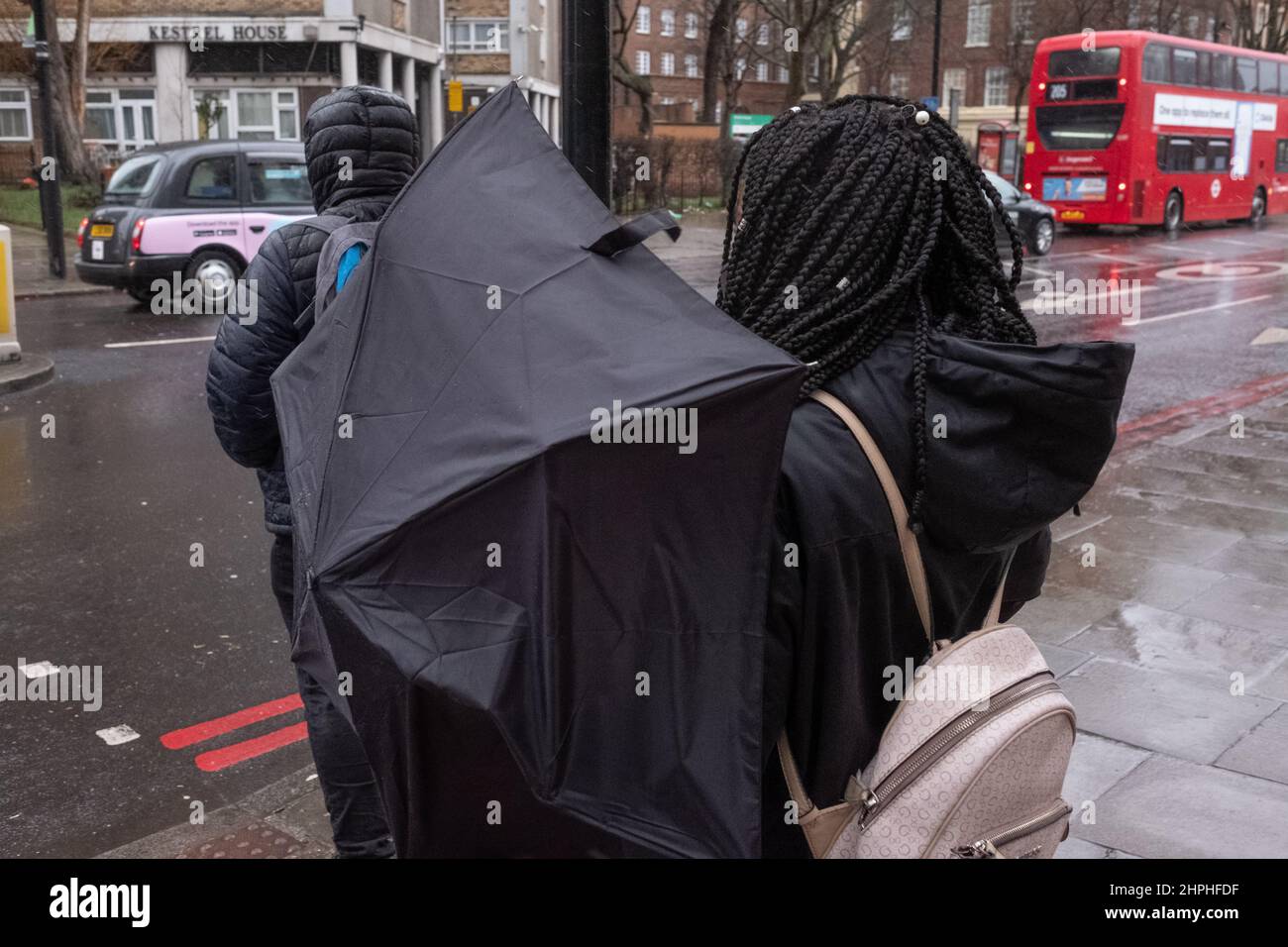 Eine Frau kämpft an einem stürmischen Tag in London, Großbritannien, mit Regenschirm Stockfoto