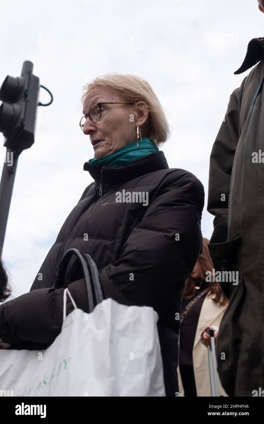Reife Hündin wartet mit einer Laura Ashley Tasche, London UK, auf die Straße Stockfoto