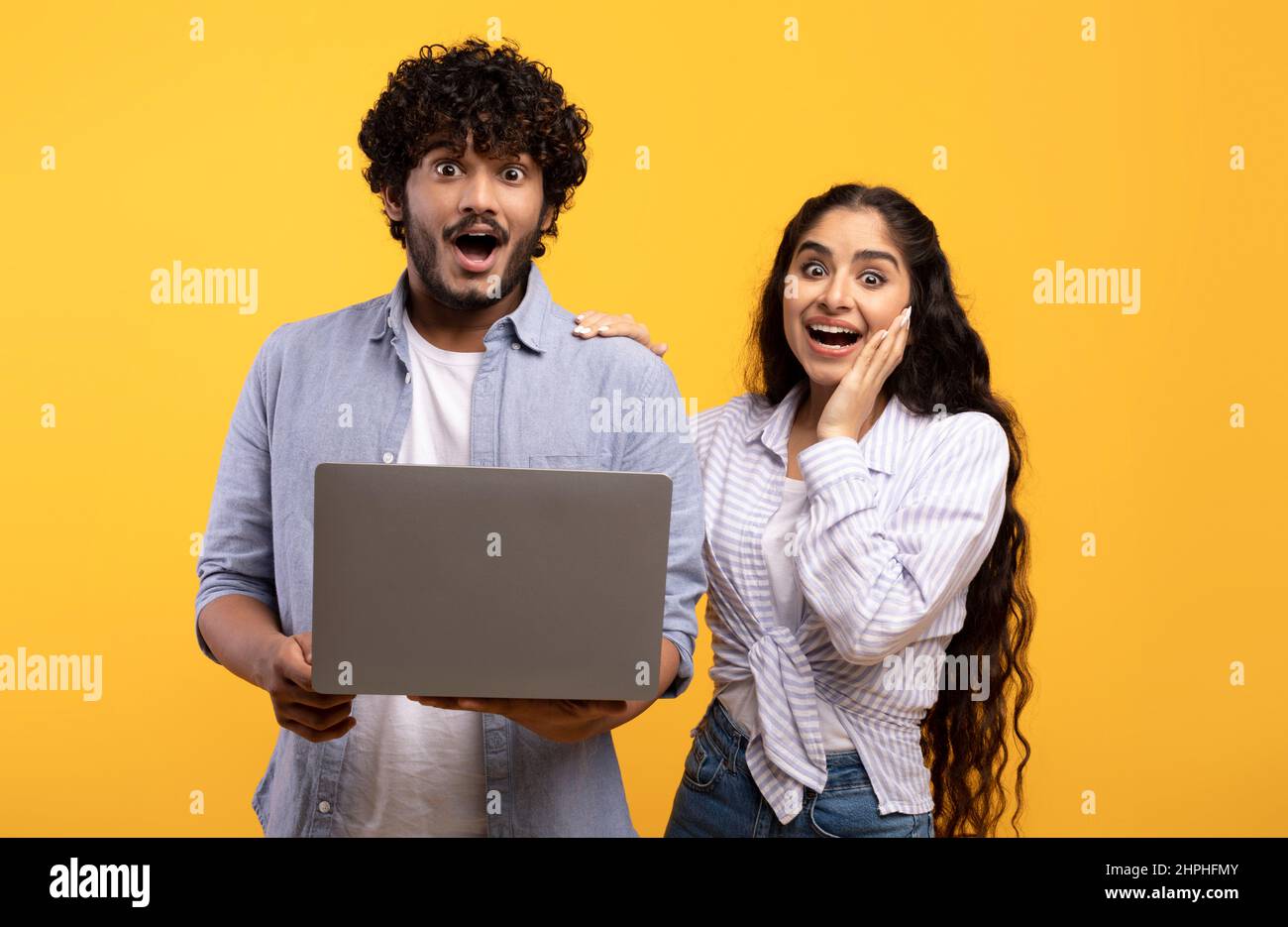 Tolles Angebot, gute Seite. Überrascht war der indische Ehemann und die indische Frau, die ihren Laptop in der Hand hielten und mit offenem Mund auf die Kamera schaute Stockfoto