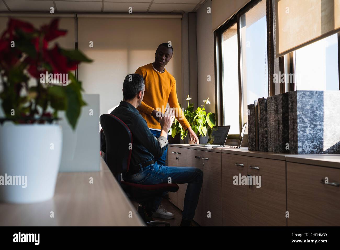 Zwei Männer verschiedener Ethnien, die in einem Büro arbeiten. Stockfoto