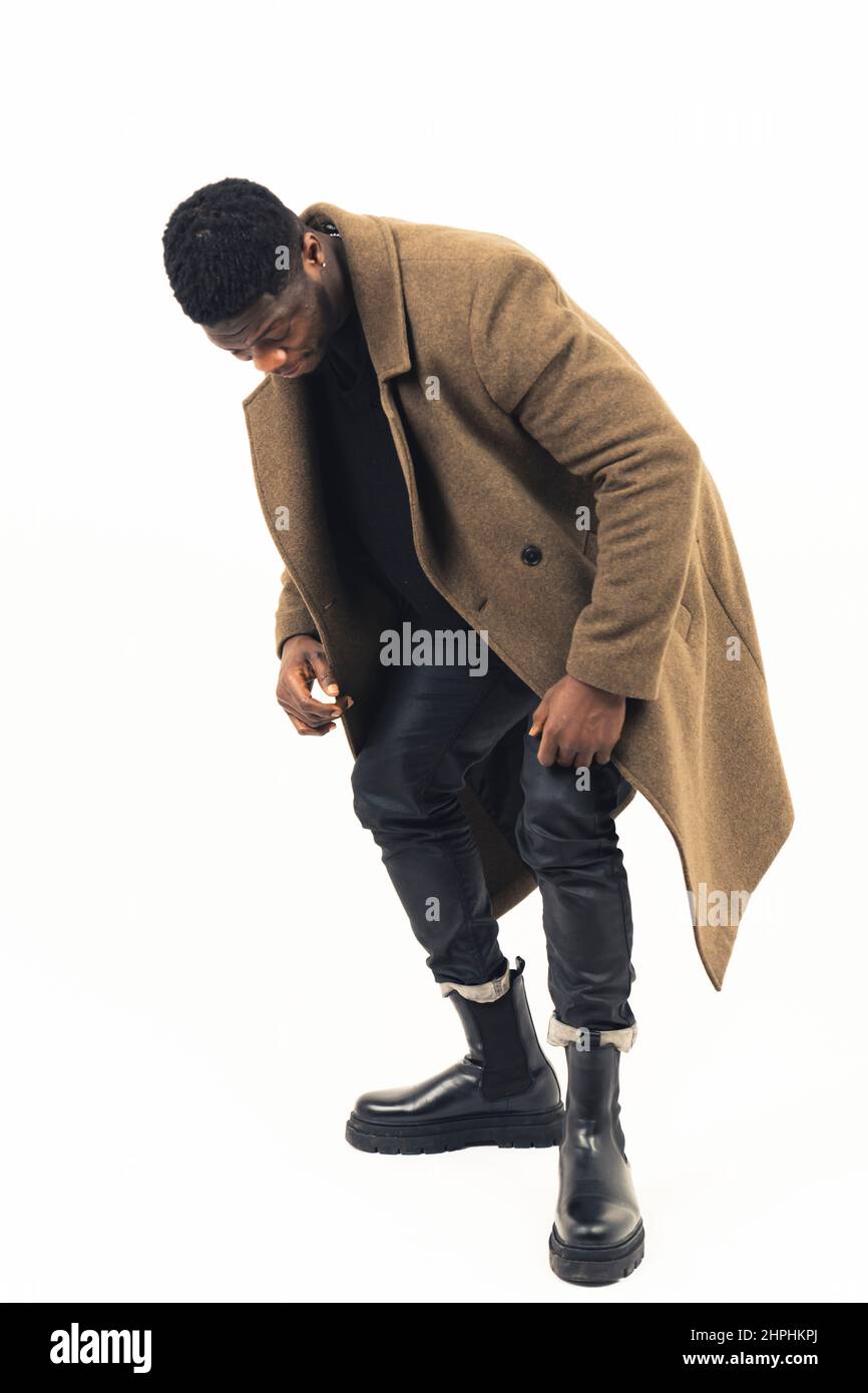 Schwarz Kerl Modellierung Blick auf seine Schuhe weißen Hintergrund - voller Schuss. Hochwertige Fotos Stockfoto