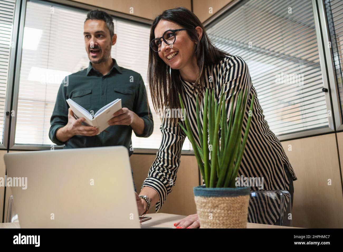Mann und Frau mittleren Alters entspannen sich während der Arbeit in einem Büro. Stockfoto
