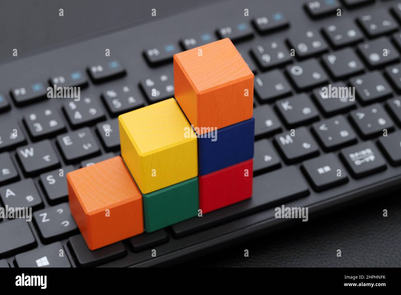 Spielzeugblock Treppe auf Computer-Tastatur auf schwarzem Tisch Stockfoto