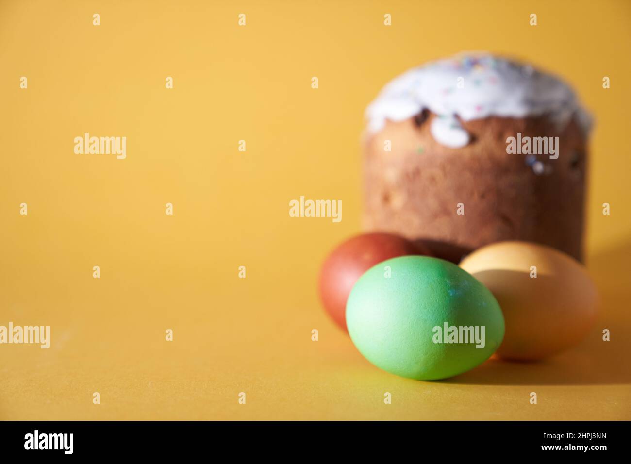 Nahaufnahme von farbigen Ostereiern und kulich auf gelbem Hintergrund. Mit einem zu kopierenden Leerzeichen. Hochwertige Fotos Stockfoto