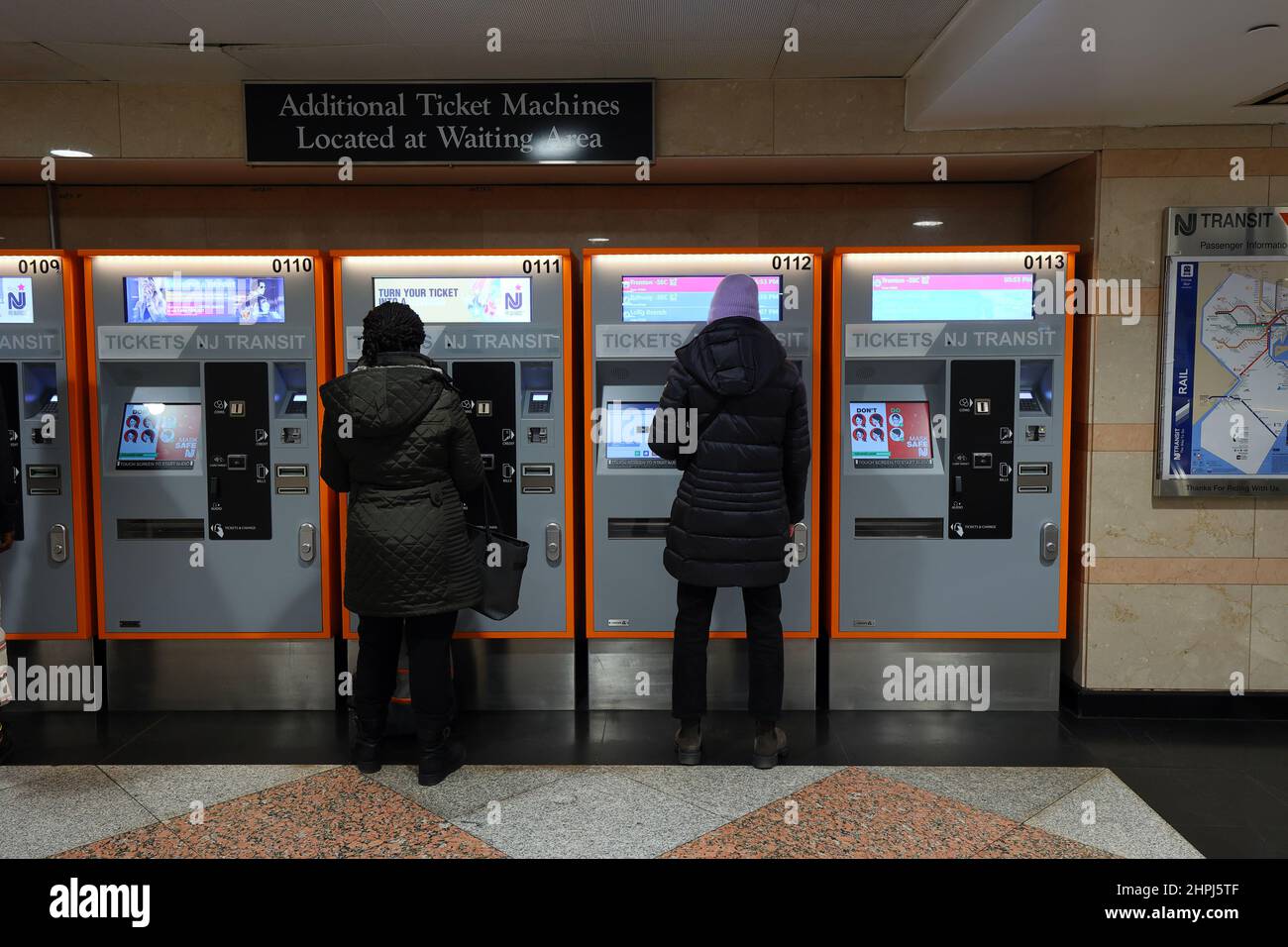 Personen, die die automatischen Fahrkartenautomaten von NJ Transit an der Penn Station, New York, NY, nutzen. Stockfoto