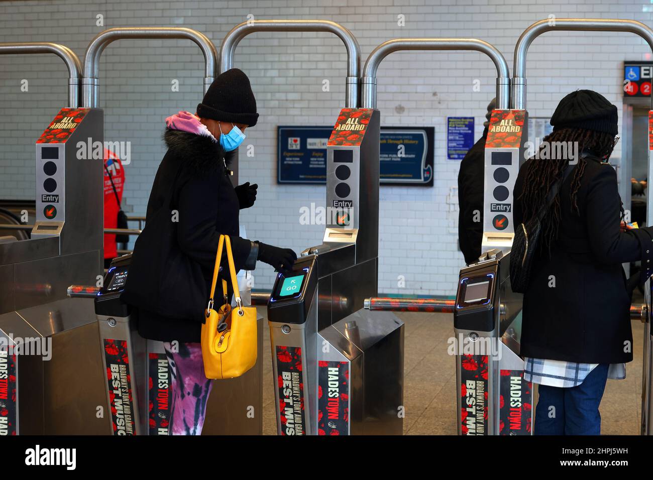 Eine Person verwendet eine kontaktlose Kreditkarte, um eine Drehkreuzweiche der nyc U-Bahn zu antippen und zu durchqueren. Stockfoto