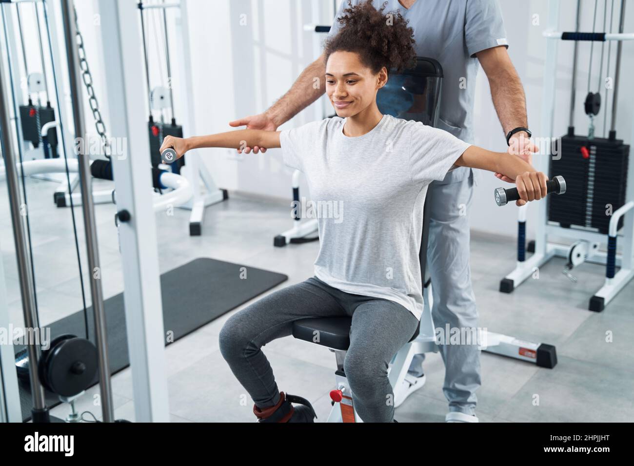 Junge Dame, die sich im Fitnessstudio einer Armrehabilitation unterzogen hat Stockfoto
