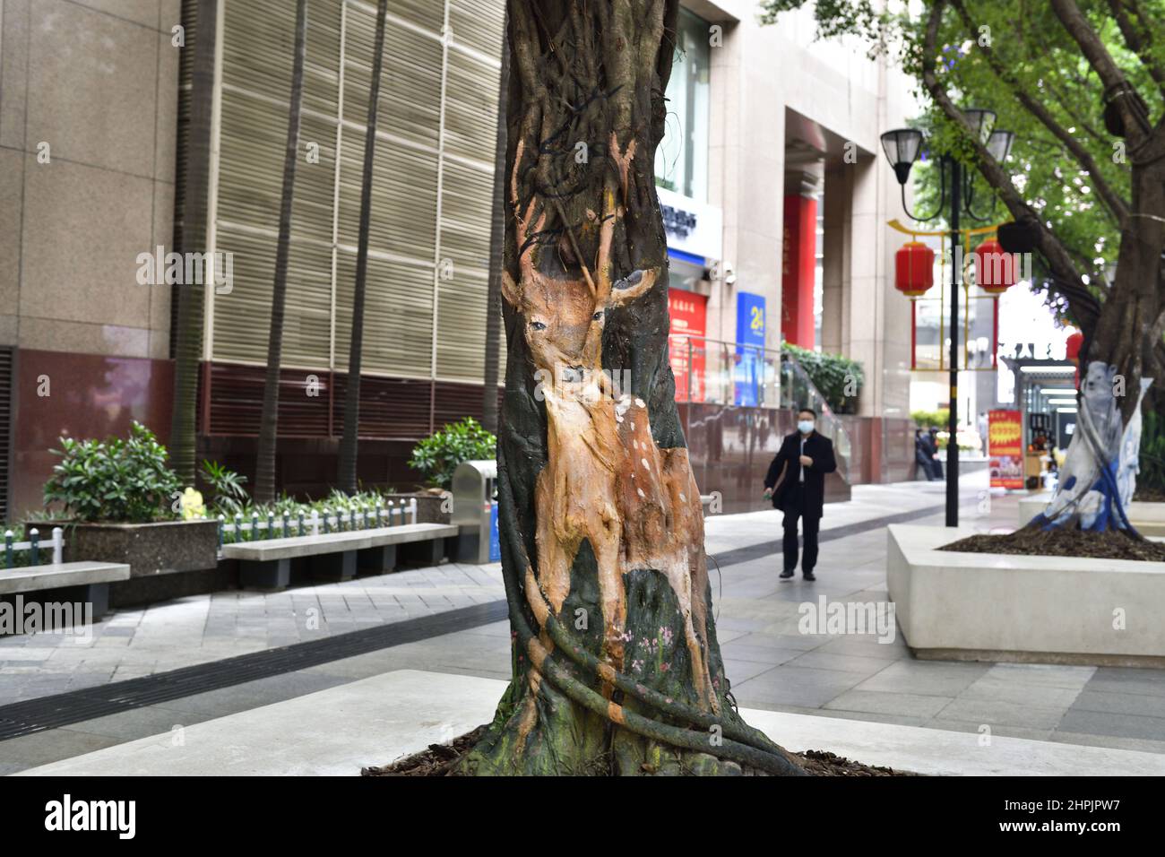 Chongqing, Chongqing, China. 22nd. Februar 2022. Am 22. Februar 2022 begann der ''Zoo'' auf dem Baum in der Jiefangbei-Fußgängerzone in Chongqing.vor kurzem, in der Jiefangbei des Yuzhong-Bezirks, Chongqing, wo beliebte Check-in-Punkte gesammelt werden, hat ein ''Zoo'' auf einem Baum begonnen, Aufmerksamkeit zu erregen. Der Reporter sah auf der Minzu Road, der Jiefangbei Fußgängerzone, dass in der Mitte der geraden Straße zwei Reihen von dichten gelben Wacholderbäumen sind. Mehr als ein Dutzend Tiere, darunter das ''Lightning''-Faultier in ''Zootopia'' und das ''Timan''-Erdmännchen in ''The Lion King''. Die Gemälde sind lebensecht und Stockfoto