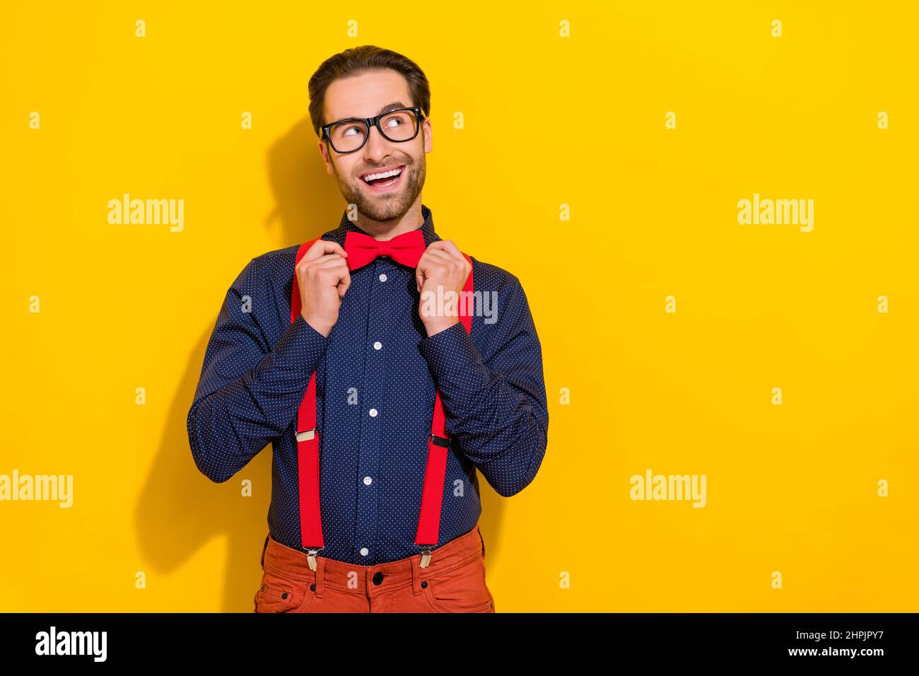 Foto von jungen fröhlichen Kerl fix bowtie verträumt denken Phantasie suchen leeren Raum isoliert über gelbe Farbe Hintergrund Stockfoto