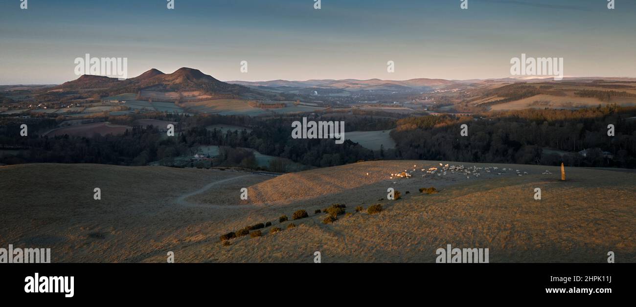 Luftaufnahme von einer Drohne eines stehenden Steins und den Eildon Hills in den Scottish Borders bei Sonnenaufgang an einem hellen Februartag. Stockfoto