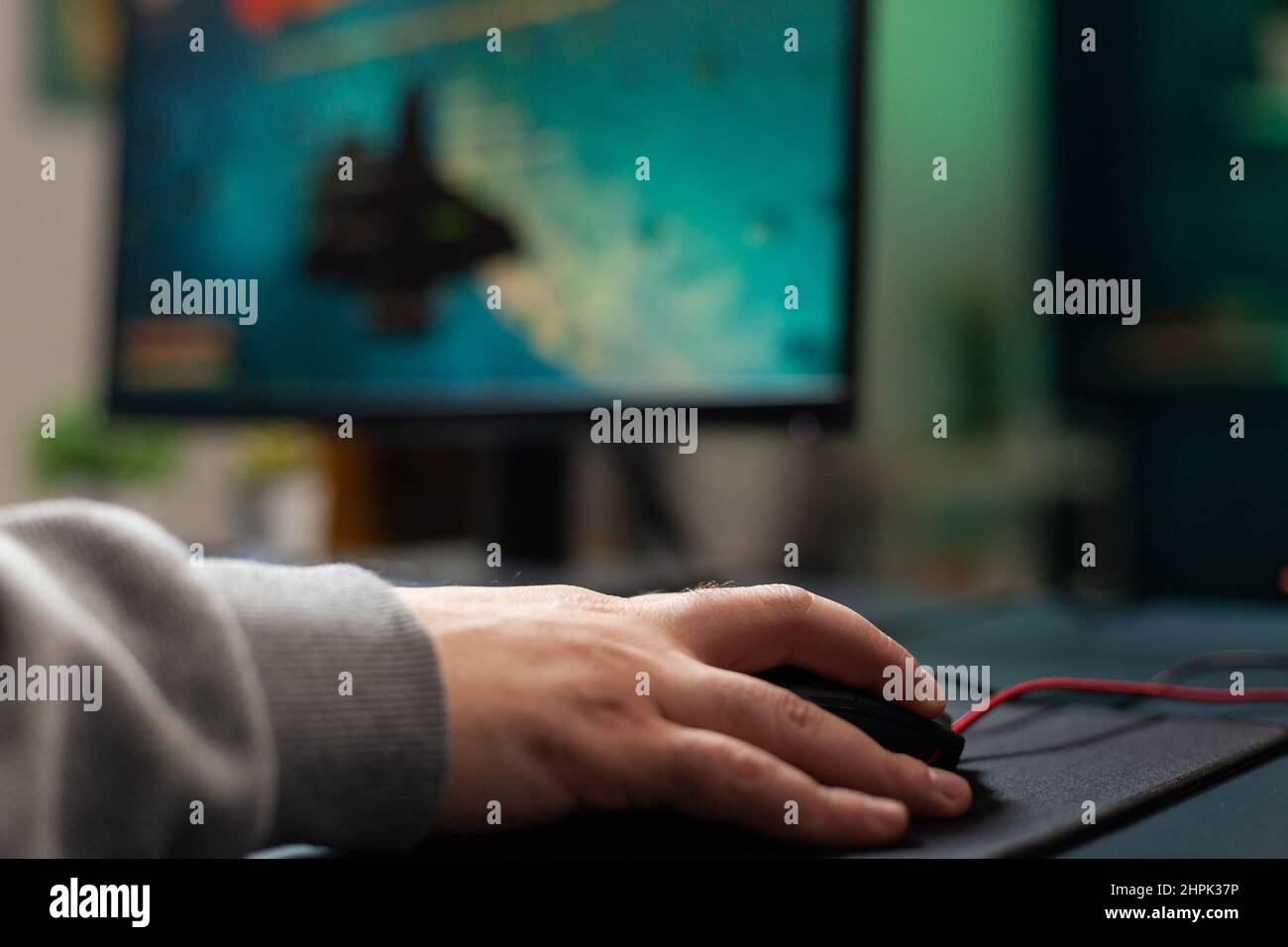Nahaufnahme eines Spielers mit Maus und Mauspad auf dem Schreibtisch, um Videospiele zu spielen. Mann mit Spielgeräten auf dem Computer, Online-Spiel zu spielen. Hand des Spielers auf Gadget Spaß mit Spielen Stockfoto