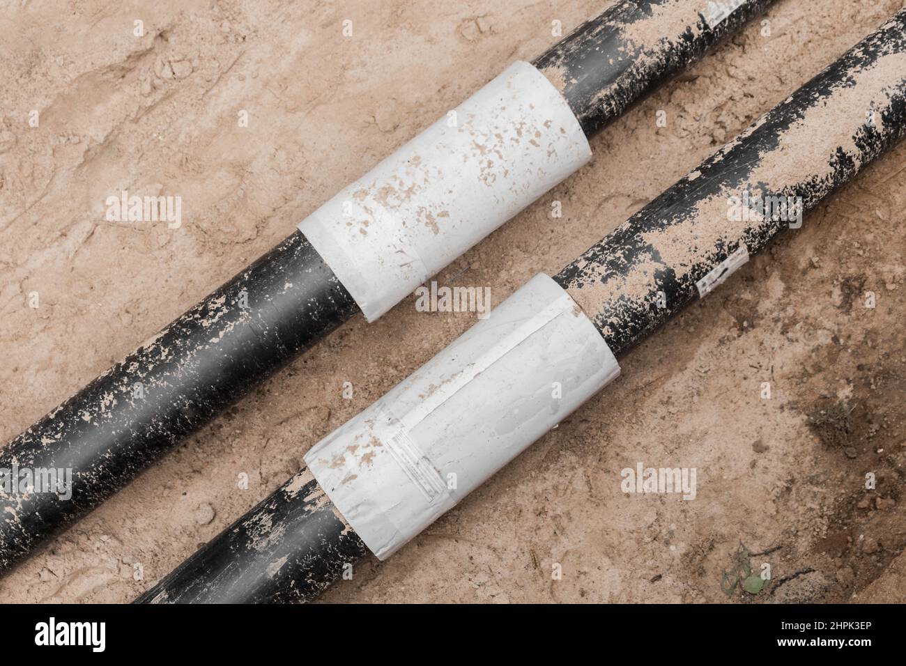 Reparatur der Wasserleitung des Heizungshauptrohrs in der Erdgraben-Pipeline auf der Baustelle. Stockfoto