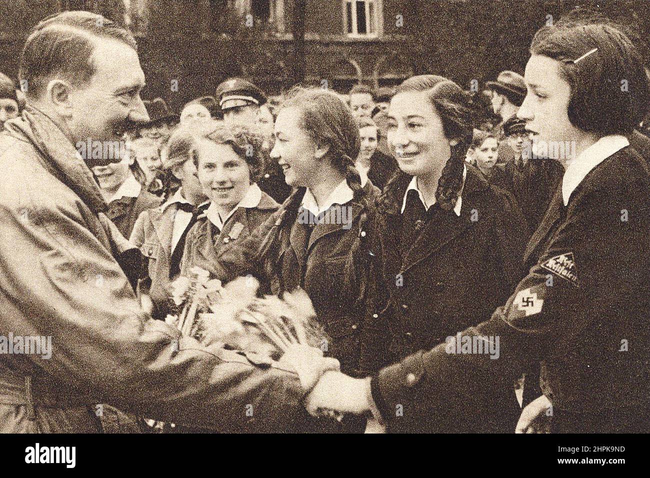 Adolf Hitler ist von Mädchen der Union Deutscher Mädchen umgeben. Deutschland, 1930s. Stockfoto