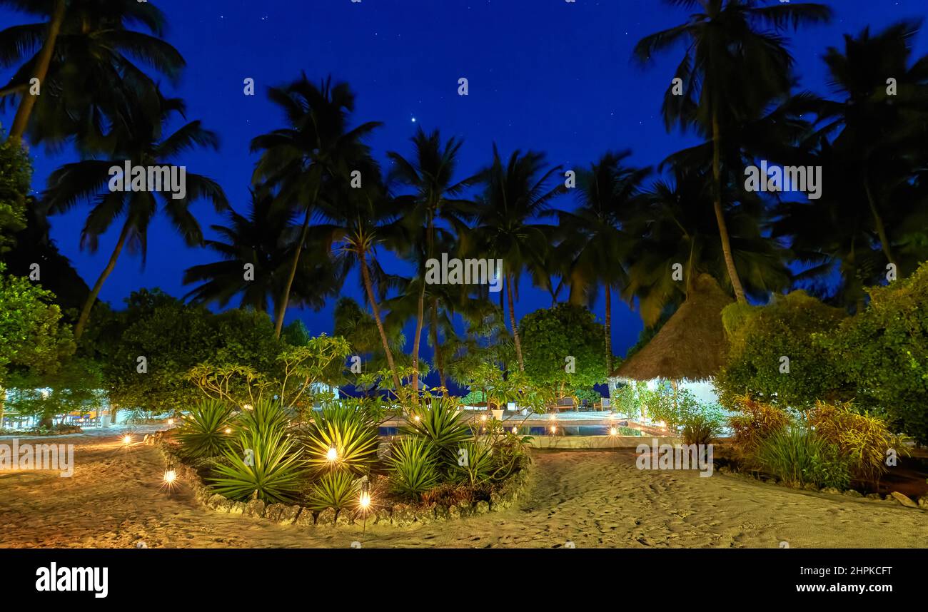 Winkende Palmen und Sternenhimmel über einem kleinen Strandhotel auf Sansibar Ostafrika Stockfoto