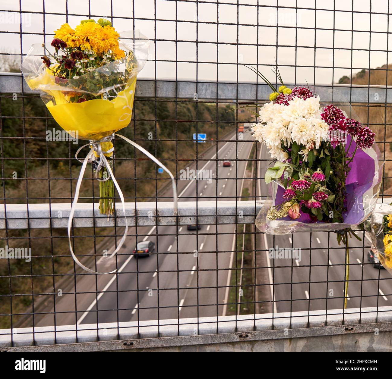 Blumensträuße, die an einer Fußgängerbrücke über die verkehrsreiche Autobahn M5 in Somerset UK befestigt sind Stockfoto
