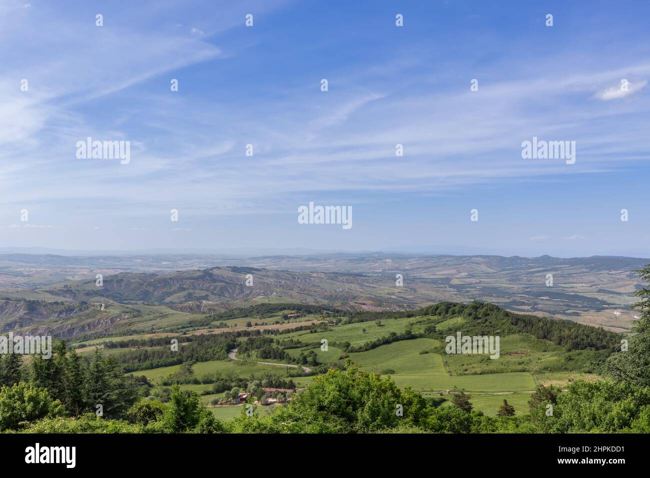 Endlose toskanische Hügellandschaft mit dem fernen Horizont und verschwommenem Himmel. Val d'Orcia, Italien Stockfoto