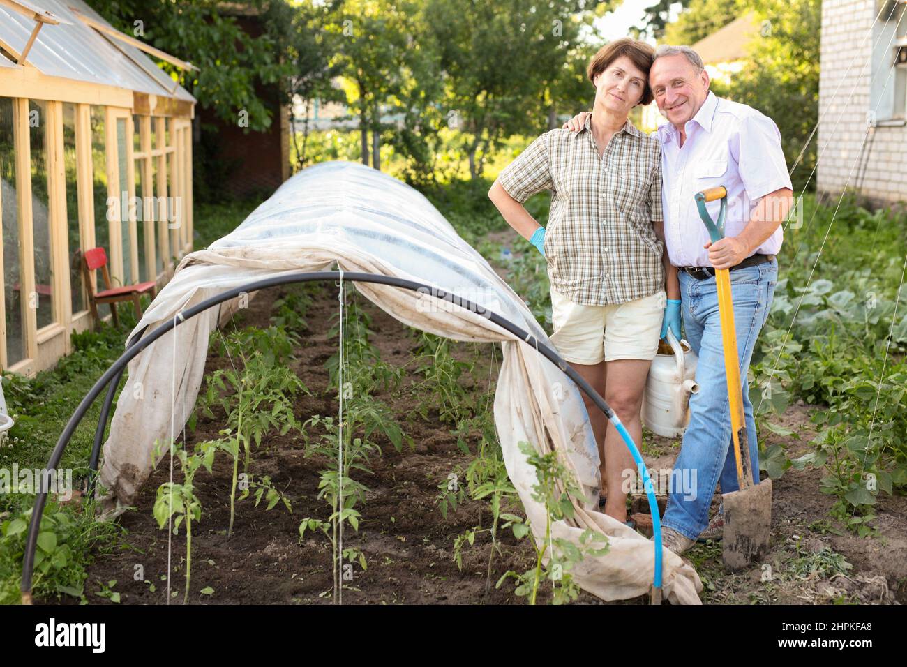 Ältere Paare halten Pflanzen vor der Kälte zurück Stockfoto