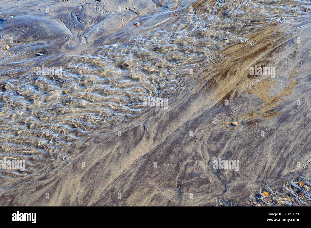 Bei Ebbe fließendes Meerwasser oder Sand. Stockfoto