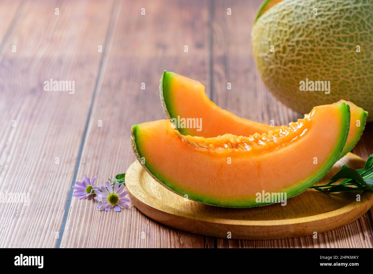In Scheiben geschnitten aus japanischen Melonen, Honigmelone oder Cantaloupe (Cucumis melo) auf Holztischhintergrund. Lieblingsfrucht im Sommer. Gesundheitskonzept. Stockfoto
