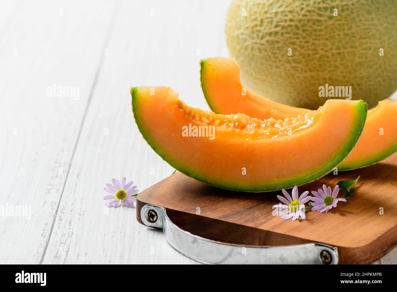 In Scheiben geschnitten aus japanischen Melonen, Honigmelone oder Cantaloupe (Cucumis melo) auf weißem Holztisch Hintergrund. Lieblingsfrucht im Sommer. Gesundheitskonzept. Stockfoto