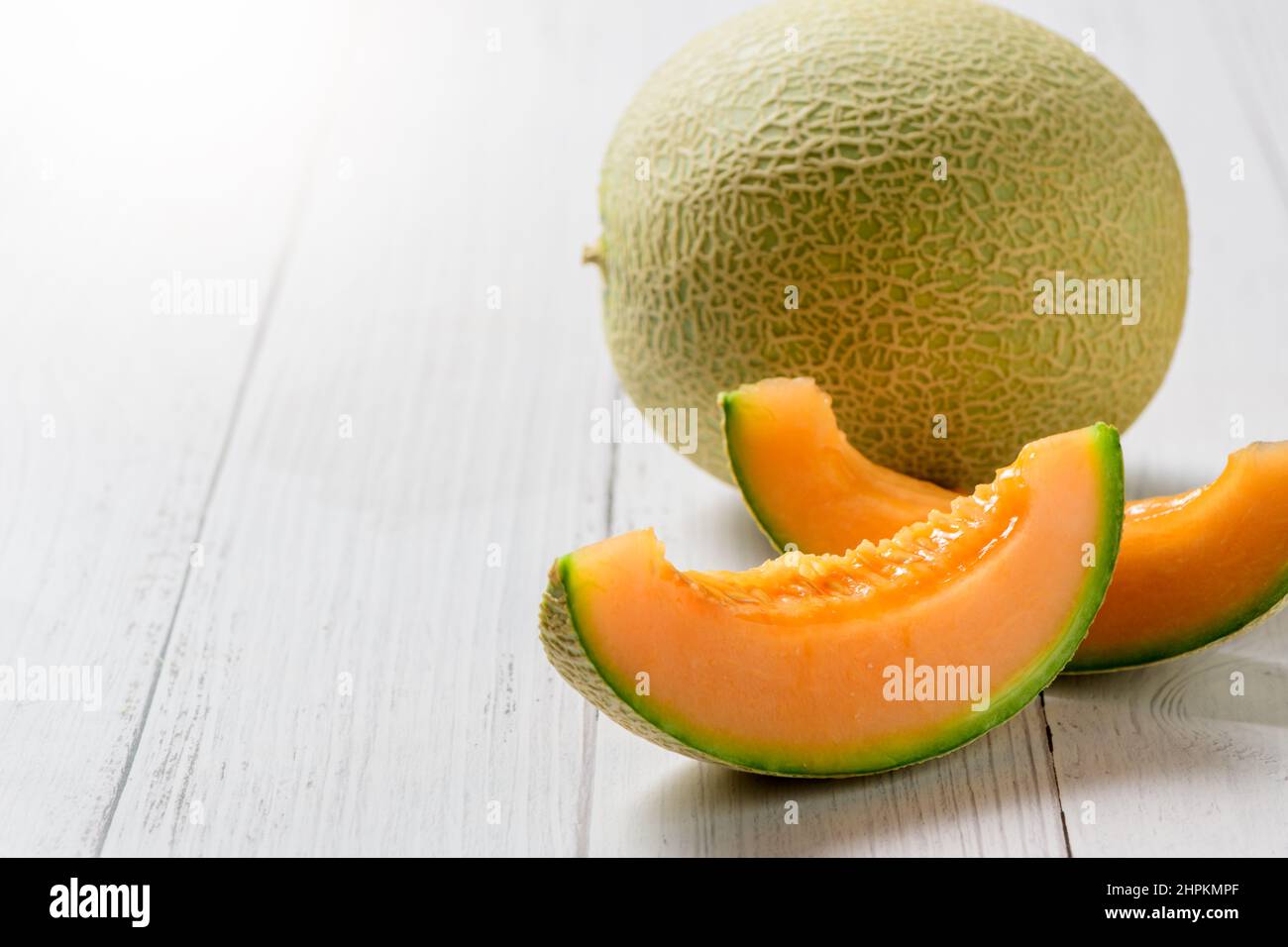 In Scheiben geschnitten aus japanischen Melonen, Honigmelone oder Cantaloupe (Cucumis melo) auf weißem Holztisch Hintergrund. Lieblingsfrucht im Sommer. Gesundheitskonzept. Stockfoto