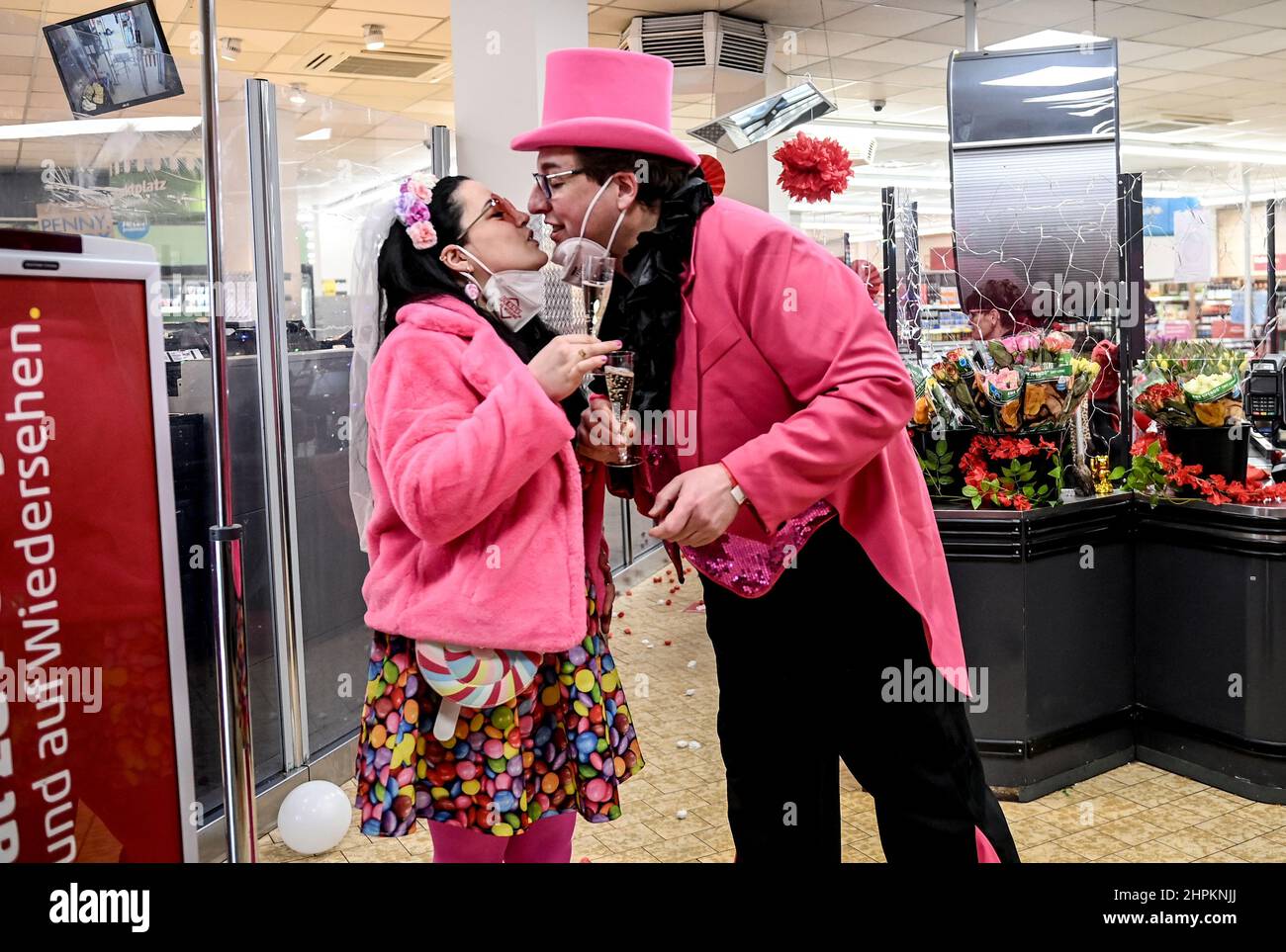 Berlin, Deutschland. 22nd. Februar 2022. Monique und Ralf küssen sich nach ihrer Hochzeitszeremonie in einer Filiale der Penny-Supermarktkette im Berliner Stadtteil Wedding. Anlässlich des begehrten Hochzeitstages im Jahr 22.02.2022 konnten Paare, die sich kurzfristig zu Wort kamen, auf der Veranstaltung „Las Wedding“ symbolisch „Ich tue“ sagen. Die Ehe ist jedoch nicht gültig. Kredit: Britta Pedersen/dpa-Zentralbild/dpa/Alamy Live Nachrichten Stockfoto