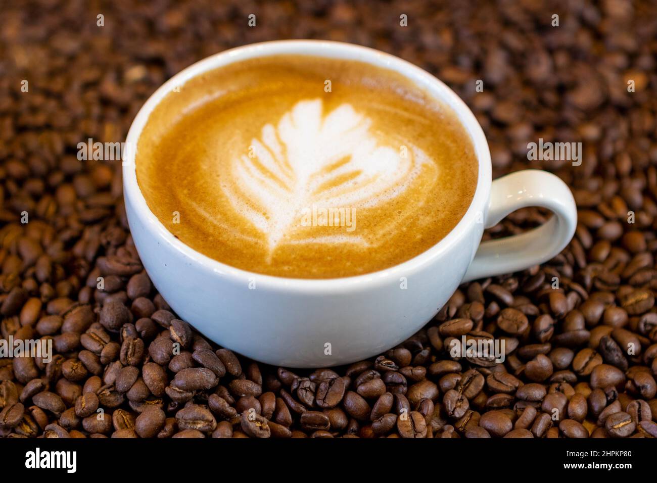 Flacher weißer Kaffee und geröstete Kaffeebohnen Stockfoto