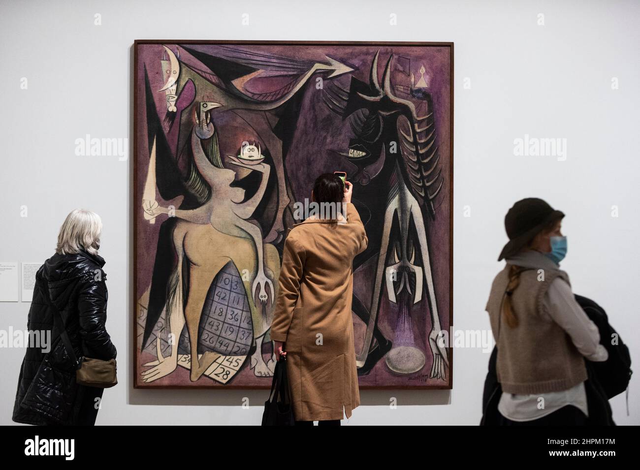 London, Großbritannien. 22. Februar 2022. Die Besucher sehen „Belial, Emperor of the Flies“, 1948, von Wilfredo Lam bei einer Vorschau auf „Surrealismus jenseits der Grenzen“, Eine neue Ausstellung in der Tate Modern, die zeigt, wie der Surrealismus Künstler auf der ganzen Welt inspiriert und vereint, basierend auf umfangreichen Forschungen der Tate und des Metropolitan Museum of Art in New York. Die Arbeiten erstrecken sich über 80 Jahre und 50 Länder und werden vom 24. Februar bis zum 29. August 2022 ausgestellt. Kredit: Stephen Chung / Alamy Live Nachrichten Stockfoto