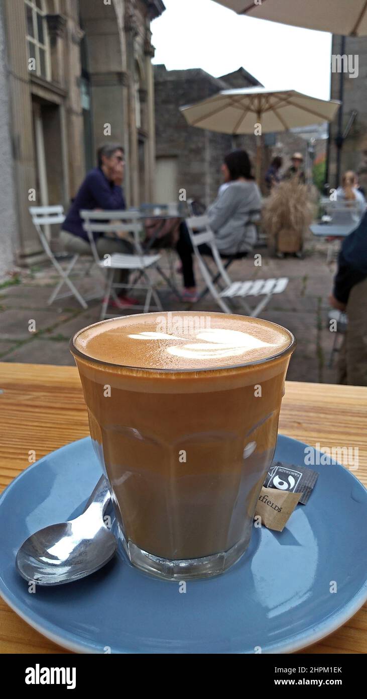 LANCASTER. LANCASHIRE. ENGLAND. 09-18-21. Hinter Der Sun Street. Eine Nahaufnahme eines Latte-Kaffees in einem Glas, das im Freien serviert wird. Stockfoto