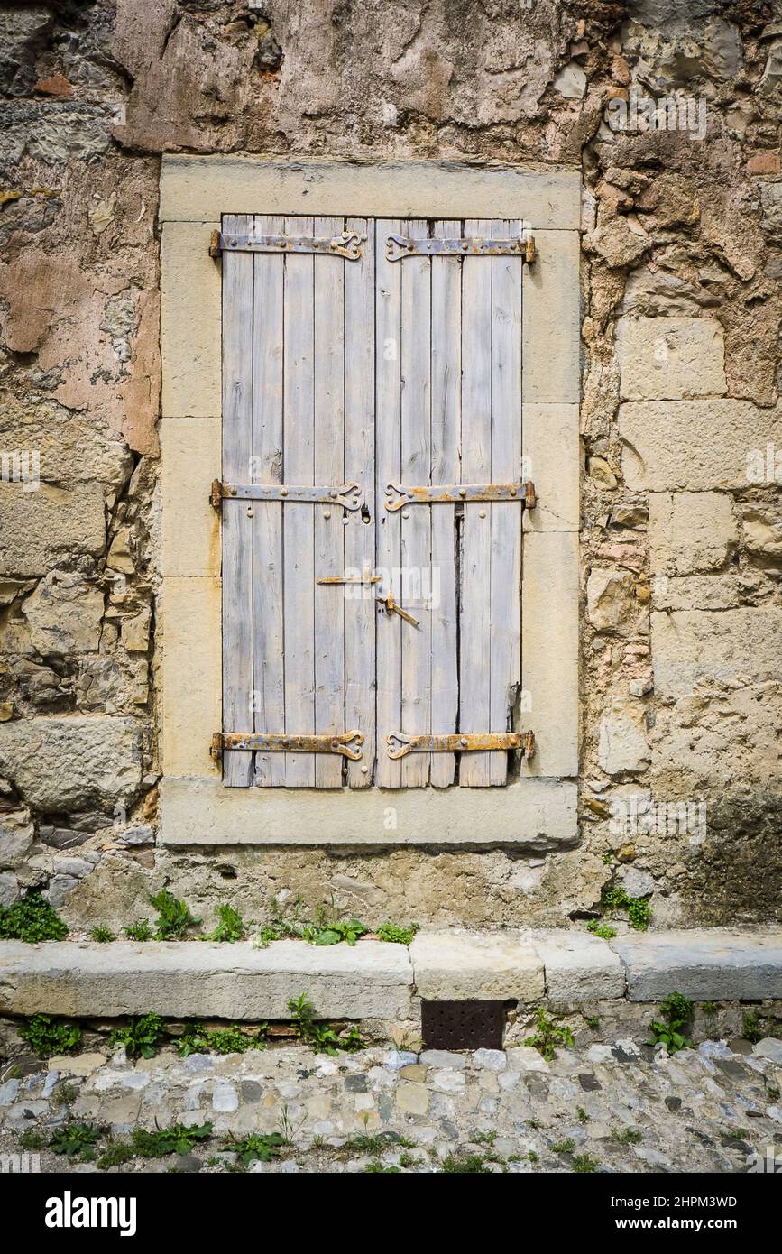 Wunderschönes Fenster mit Fensterläden in einer traditionellen Steinmauer eines alten Gebäudes Stockfoto Wunderschönes Fenster mit Fensterläden in einer traditionellen Steinmauer eines alten Gebäudes Stockfoto