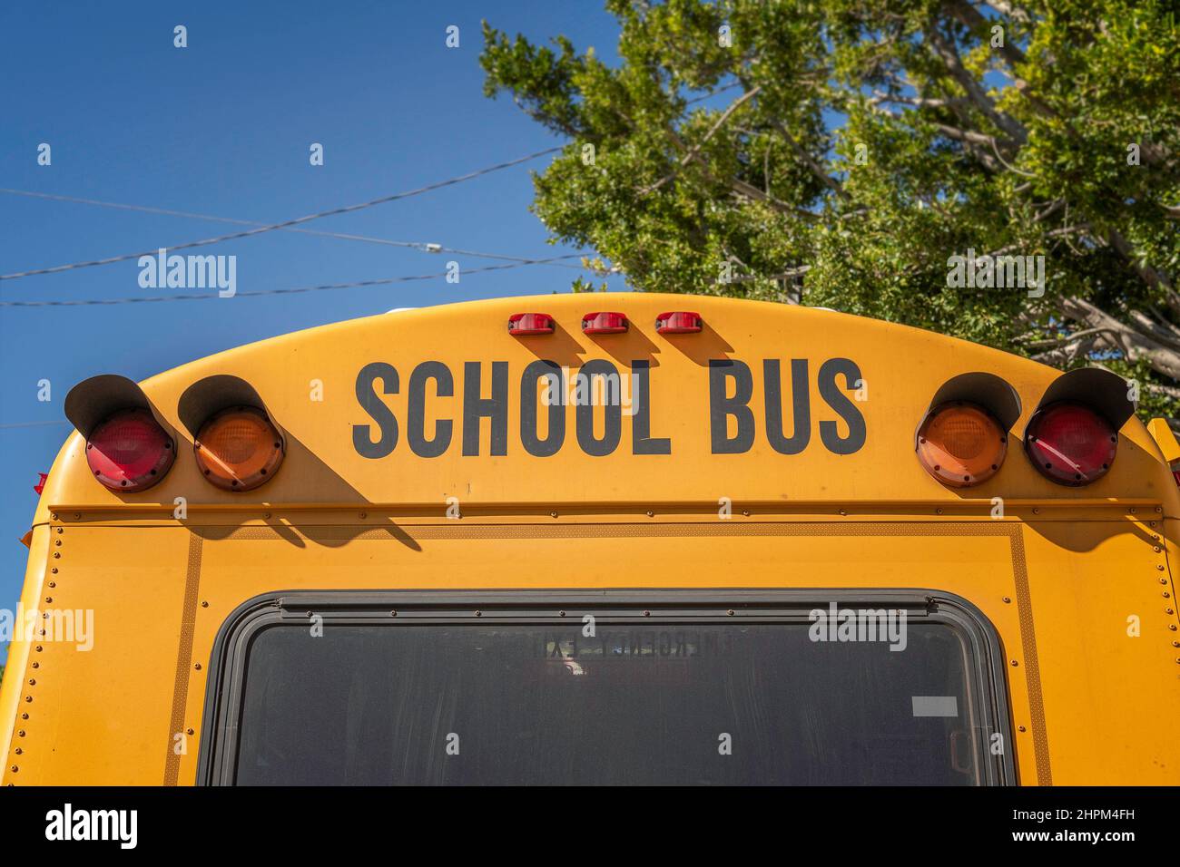 Die Rückseite eines Schulbusses vor einer Grundschule. Stockfoto