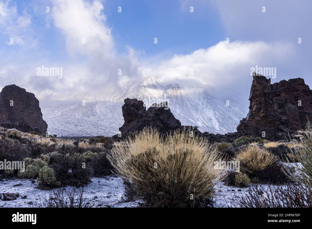Die Roques de Garcia-Formationen im Schnee und der von Wolken verdeckte Teide-Berg im Nationalpark Las Canadas del Teide, Teneriffa, Kanarische Inseln, S Stockfoto