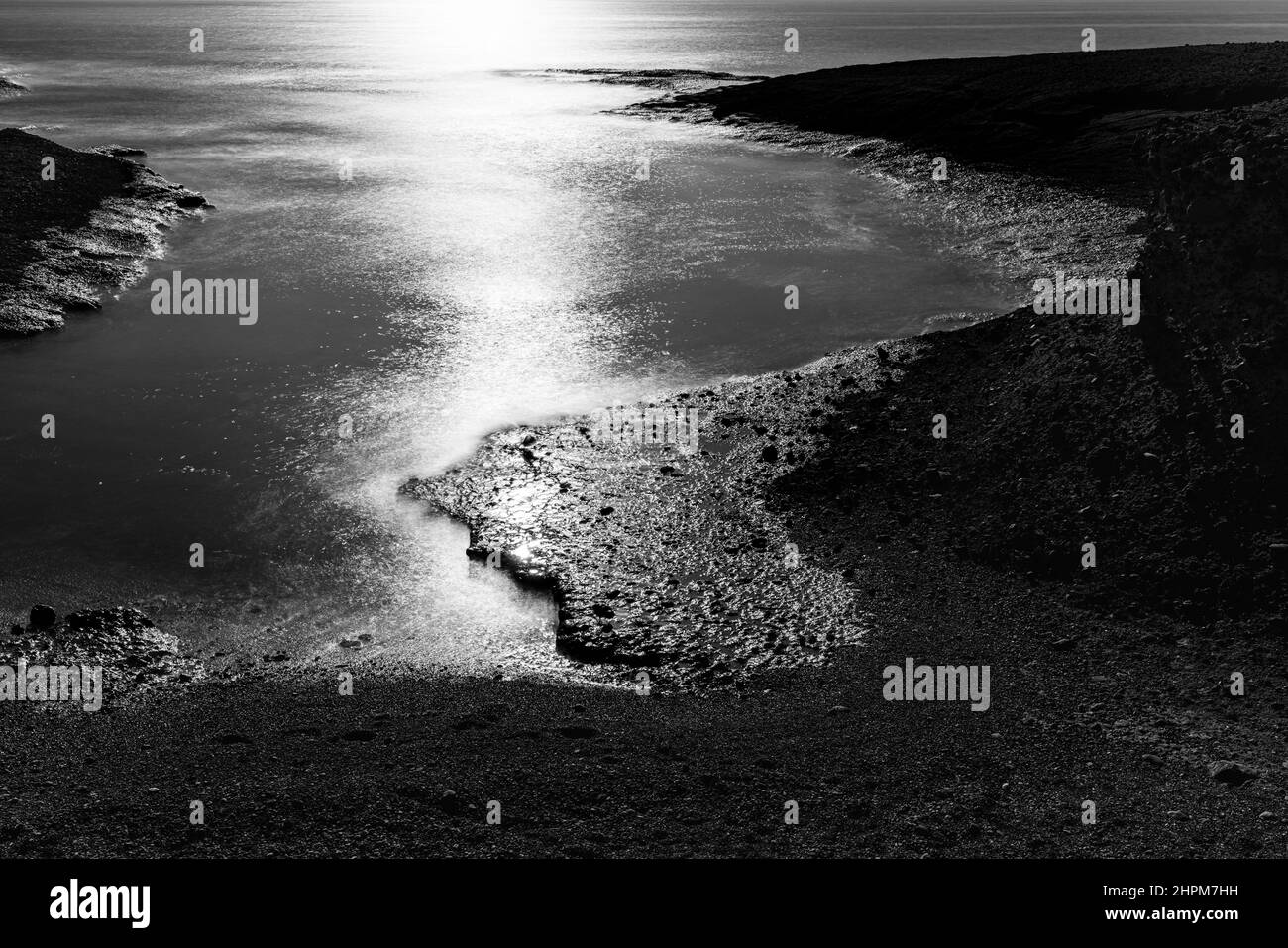 Langzeitaufnahme einer Meeresbucht mit Sonnenlicht, das vor dem Wasser in Tajao, Teneriffa, Kanarische Inseln, Spanien, scheint Stockfoto