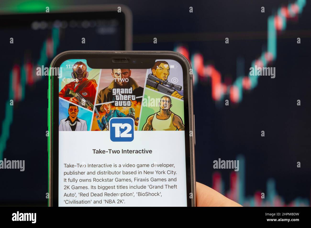 Nehmen wir zwei interaktive T2-Aktienkursen, die am Trading-Markt steigen, mit einem Balkendiagramm mit Aufwärtstrend-Linien im Hintergrund. Mann mit Mobiltelefon und Firmenlogo, Februar 2022, San Francisco, USA Stockfoto