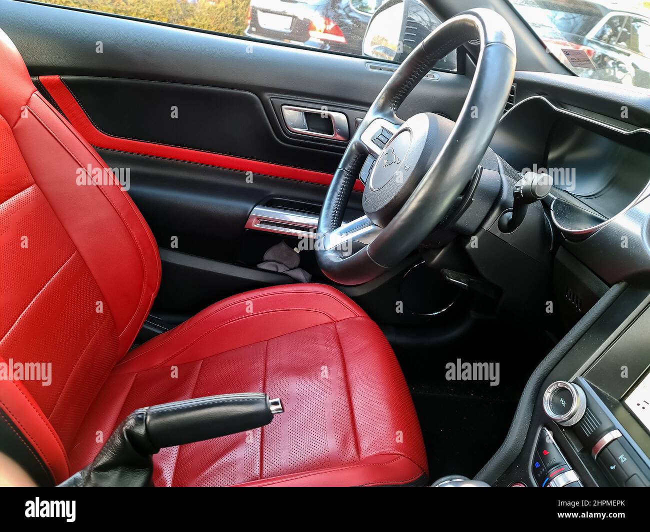 Kiel, Deutschland, 21.Februar 2022: Seitenansicht des Lenkrads eines 2018 Ford Mustang Sportwagens mit roten Ledersitzen Stockfoto