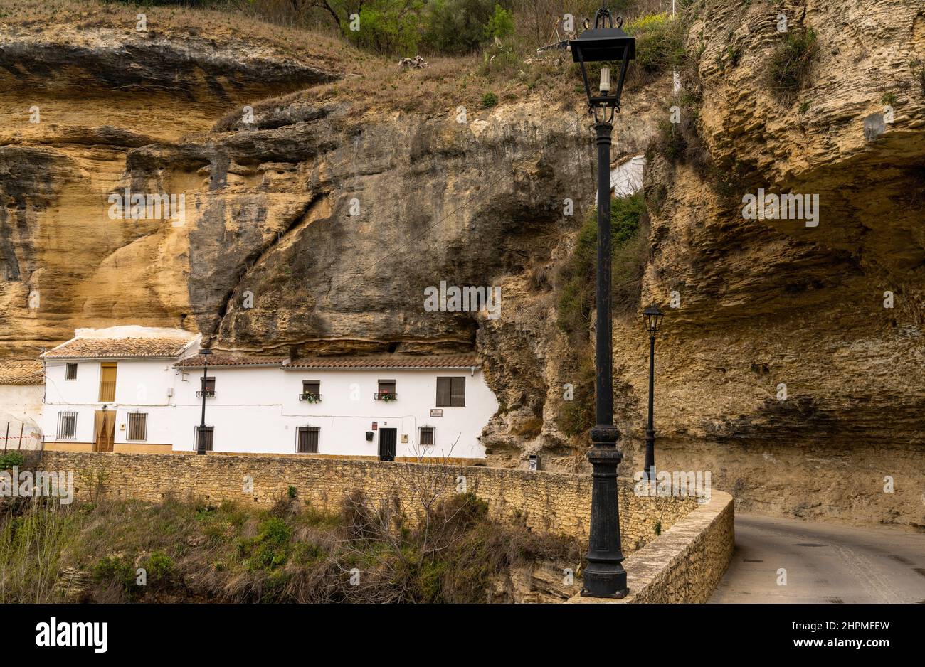 Setenil de las Bodegas, Spanien - 19. Februar 2022: Historische, weiß getünchte Entwässerungen unter Felsüberhängen entlang des Rio Trejo Stockfoto