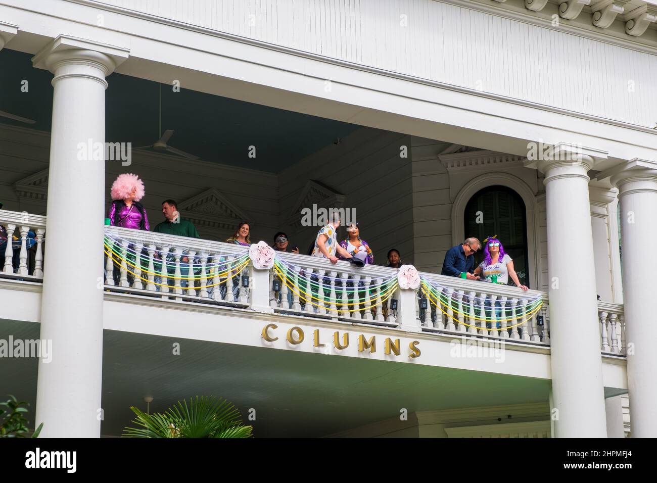 NEW ORLEANS, LA, USA - 20. FEBRUAR 2022: Menschen beobachten die Femme Fatale Parade vom Balkon des historischen Columns Hotel auf der St. Charles Avenue Stockfoto
