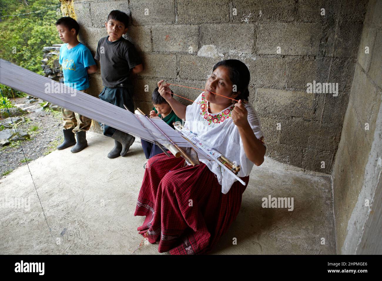 Hebamme Thelma Maxlatz, als sie zu Hause im Dorf Yuhilxa in Guatemala am Webstuhl webt Stockfoto