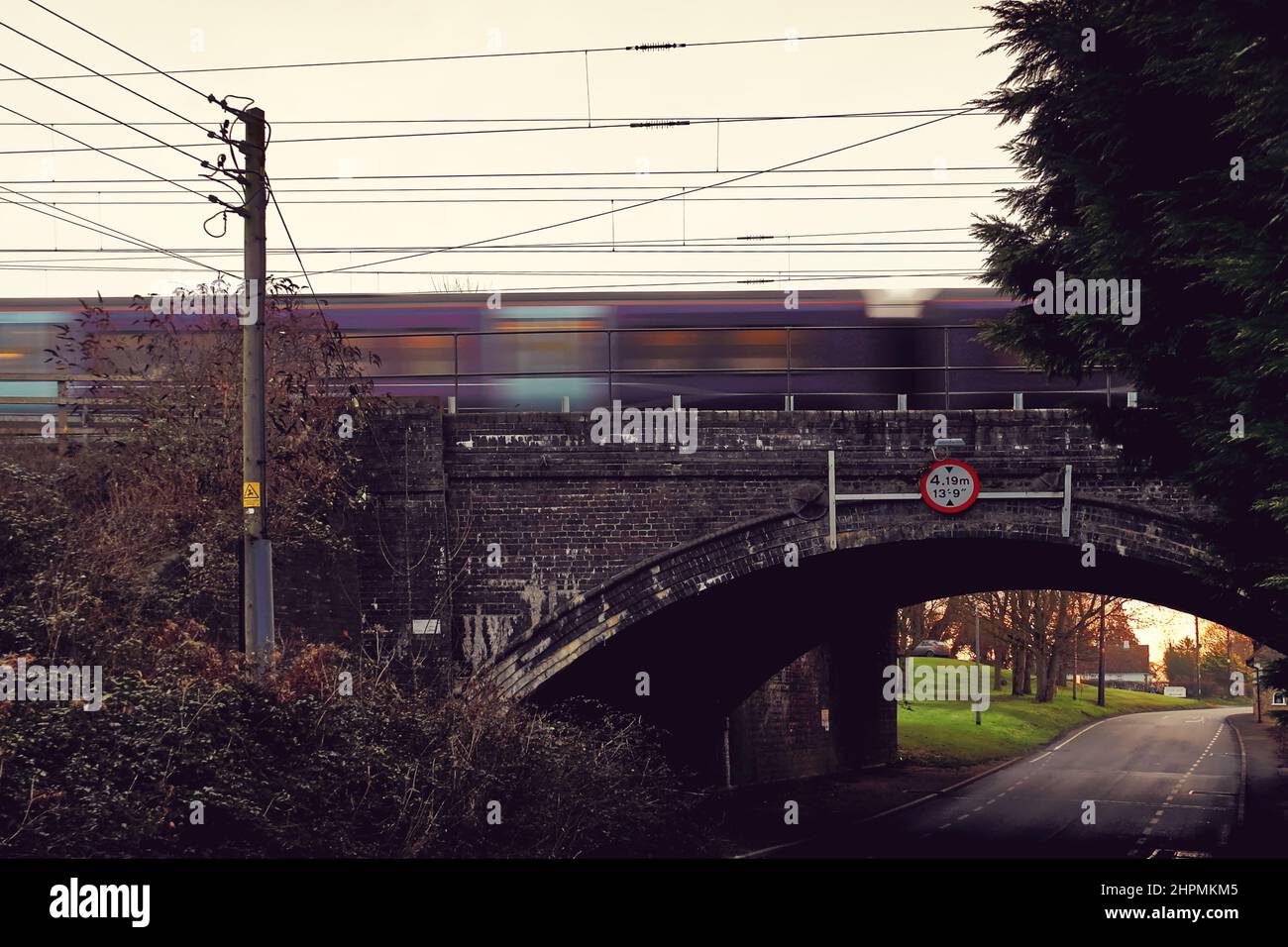 East Midlands Railway Regional Diesel mehrere Zuggeschwindigkeiten über eine alte Straßenbrücke mit Höhenbeschränkung in Sharnbrook, Bedfordshire, England, Großbritannien Stockfoto