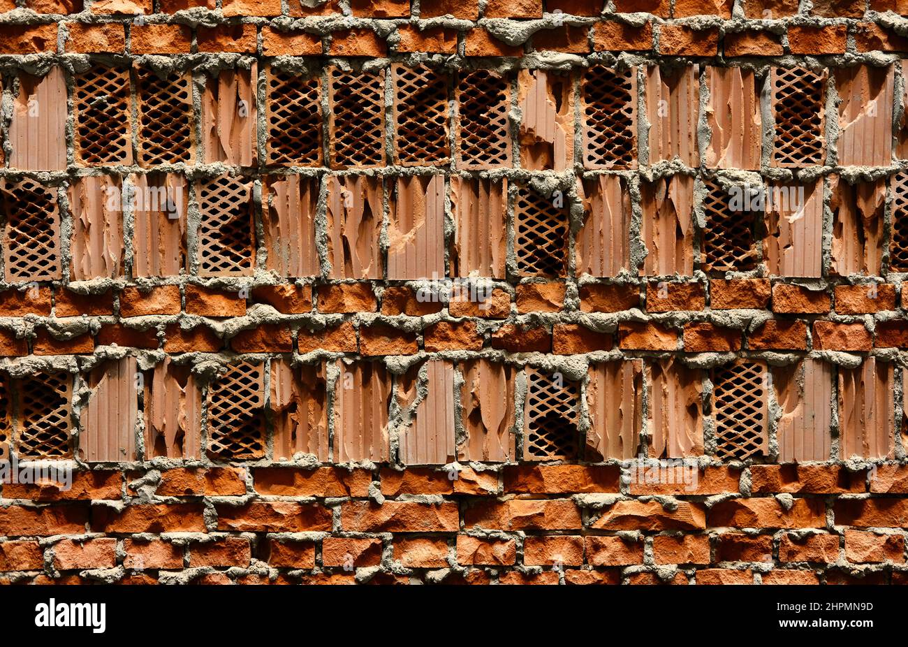 Orange perforierte Hohlraum Ziegelwand strukturierten Hintergrund Stockfoto
