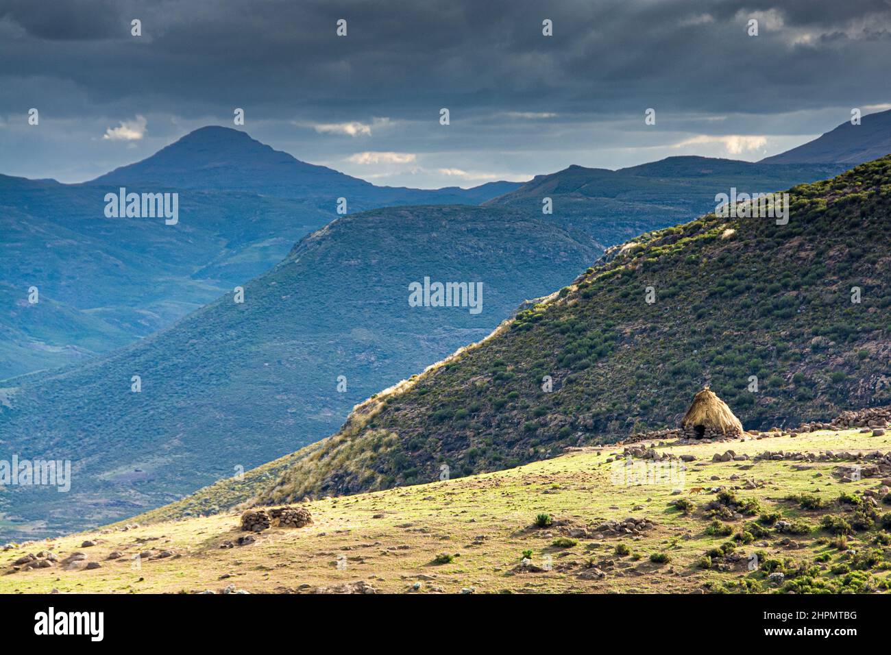 Reise nach Lesotho. Ein Rondavel, die traditionelle Hütte der Basotho-Hirten, liegt in einer spektakulären Berglandschaft Stockfoto