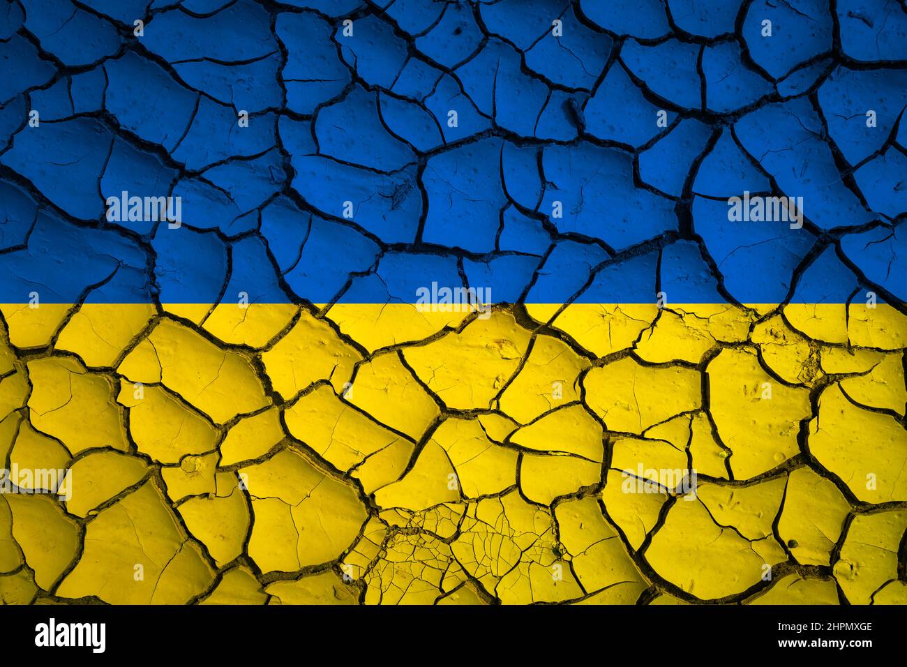 Ukrainische nationale blaue und gelbe Flagge auf einer Schlammstruktur von trockenen Rissen auf dem Boden Stockfoto