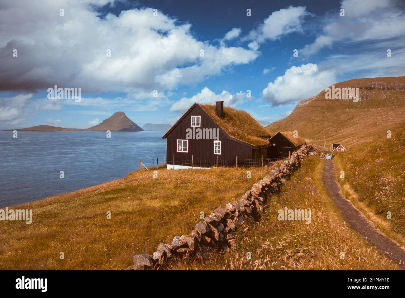 Nebliger Blick auf ein Haus mit einem typischen Rasendach im Dorf Velbastadur auf der Insel Streymoy, Färöer, Dänemark. Landschaftsfotografie. Farben für Retro-Filmscans Stockfoto