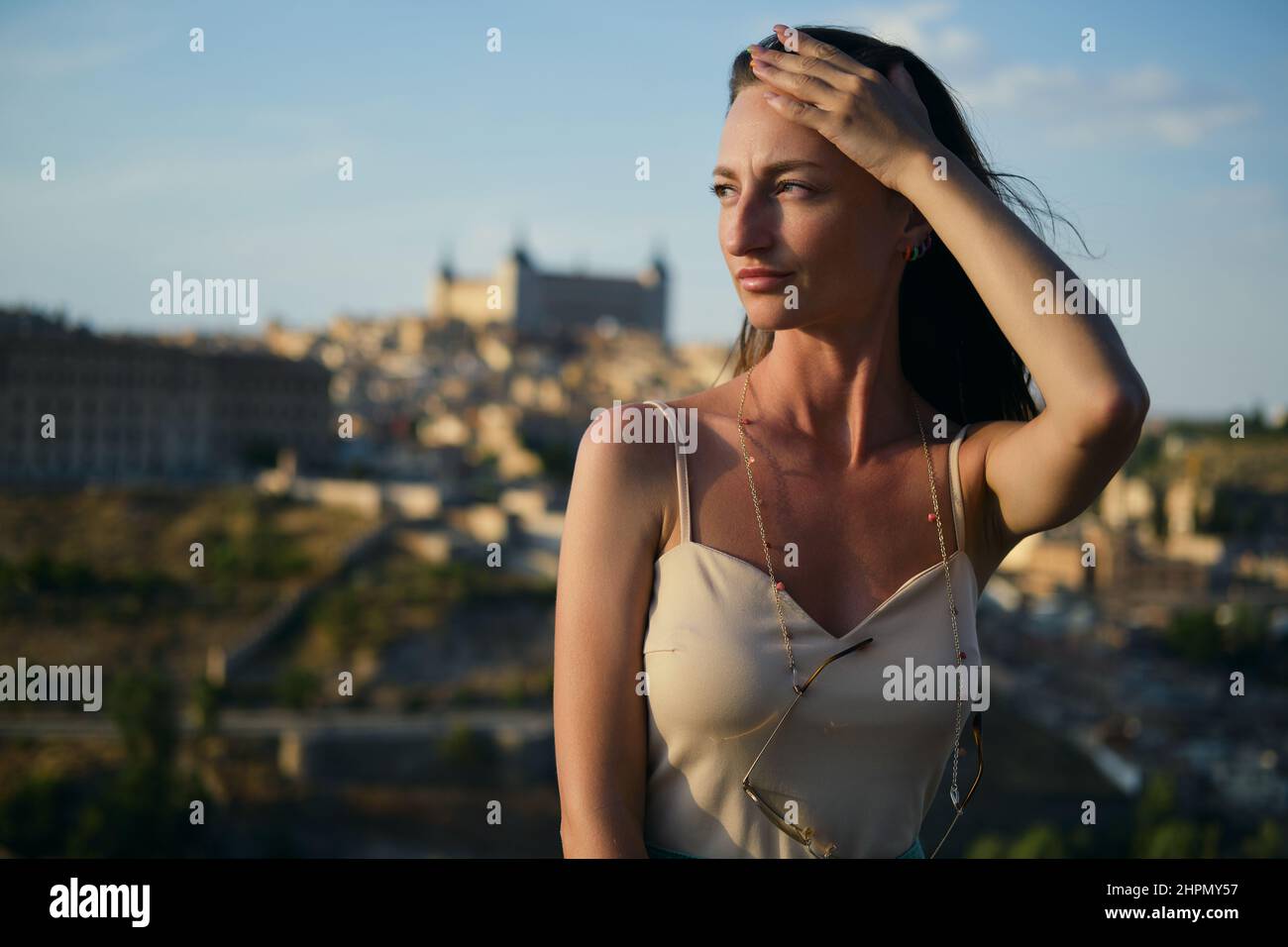 Schöne junge 30s Frau posiert vor Toledo Stadtbild Hintergrund. Weibliche Touristen genießen berühmte Orte und Sehenswürdigkeiten. Castilla-La Mancha. Travel des Stockfoto